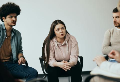Ryhmä ihmisiä käy dialogia ringissä. 