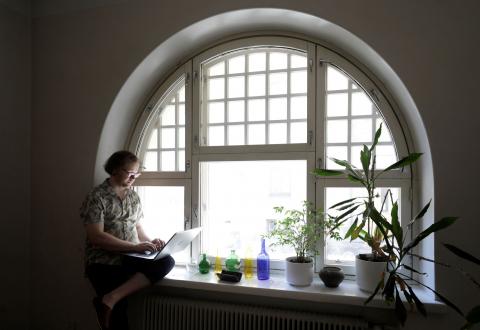 Haastatelta Severi Hämäri istuu tietokoneen kanssa työhuoneensa ikkunalaudalla.